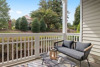 a patio with a couch and a table on a porch at The Enclave at Crossroads, Raleigh, 27606